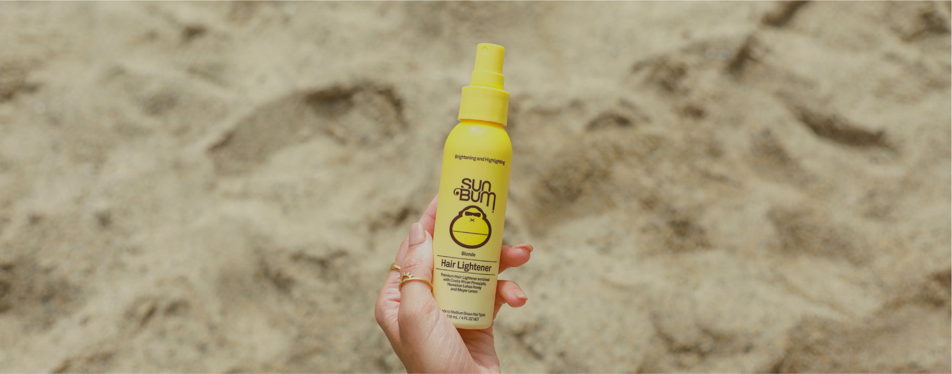 Sun Bum Blonde Hair Lightener in hand at the beach