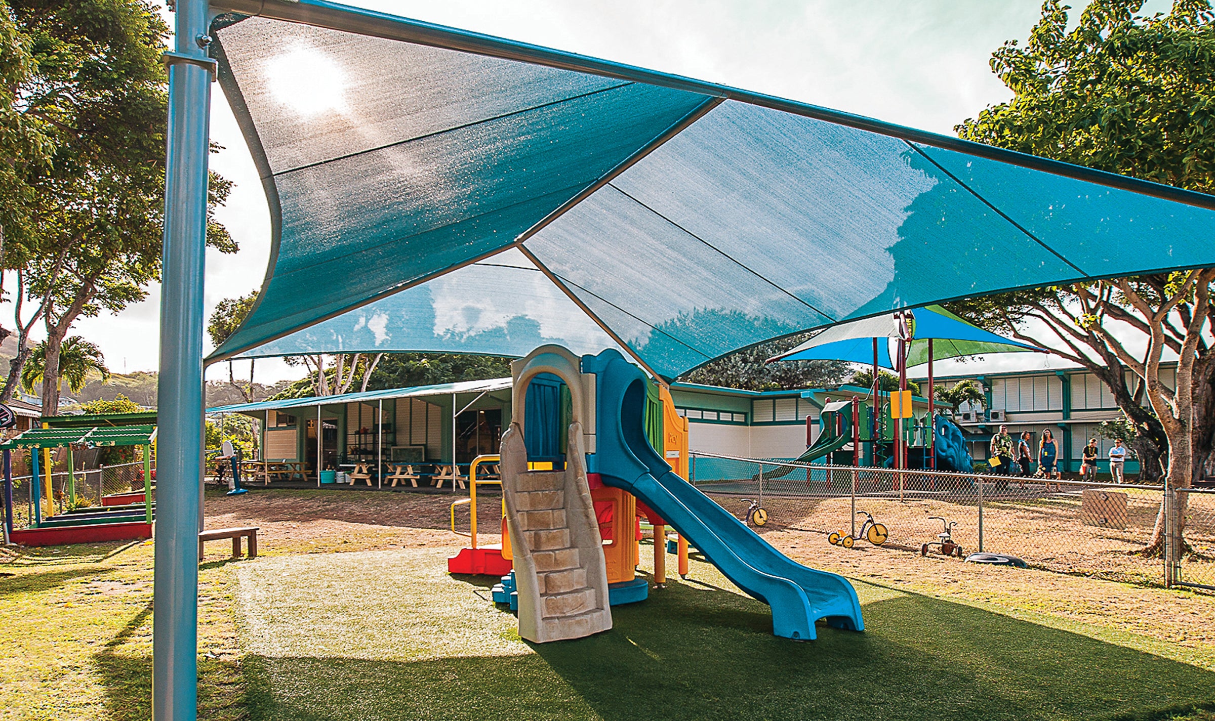 Playground covered by large shade sails to protect kids from sun exposure at school – Project The Green Collection - Sun Bum.