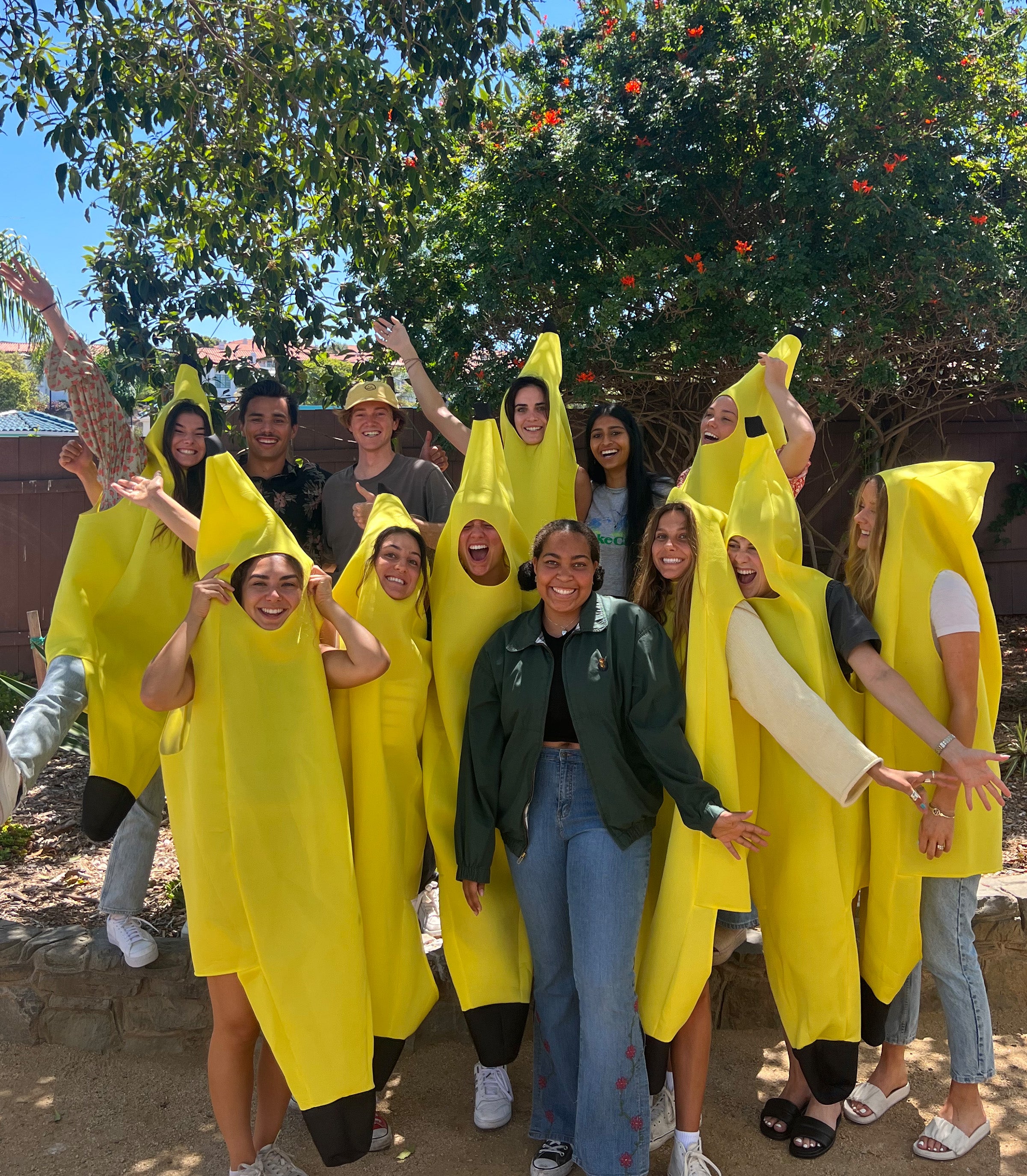 Group of Sun Bum interns smiling in banana costumes during a sunny team event – Summer Internship Collection - Sun Bum.